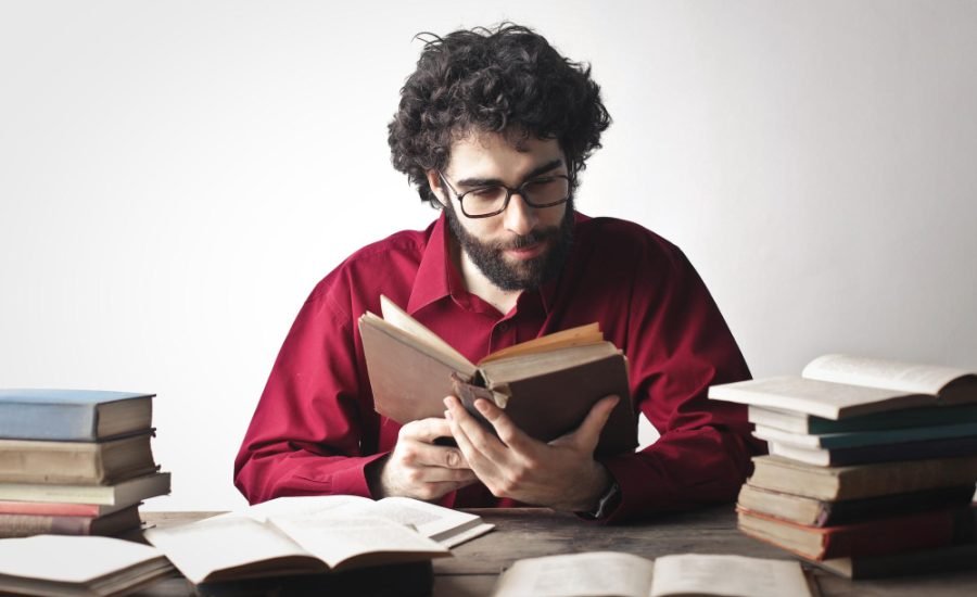 portrait young man while studying books 900x550